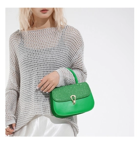 Détail du sac à main vert vif avec rabat à paillettes et boucle métallique dorée