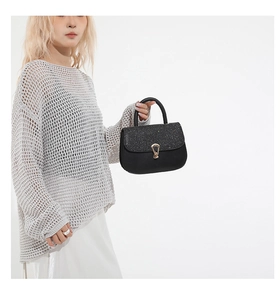 Détail du sac baguette noir avec patchwork de paillettes et boucle en métal doré