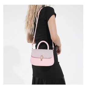 Vue détaillée du sac à main rose pailleté avec boucle dorée porté par un mannequin