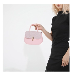 Détail du sac rose avec strass brillants, fermoir doré et finition en cuir lisse