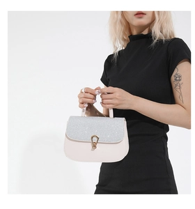 Détail d'un sac à bandoulière rose minimaliste avec finition pailletée et fermoir doré chic