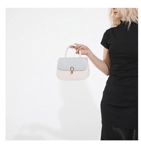 Détail d'un sac à main blanc élégant avec paillettes argentées et fermoir doré