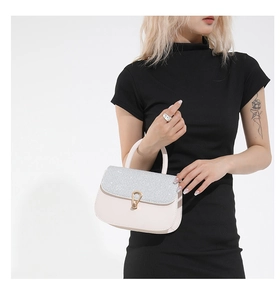 Détail du rabat pailleté et fermoir goutte doré sur le sac à bandoulière rose clair