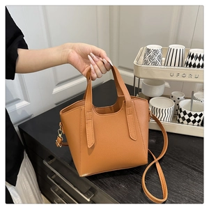 Detailed shot of brown lychee texture tote bag with gold hardware and dual handles