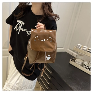 Detail of a brown glossy PU leather cat backpack showing drawstring and flap closure