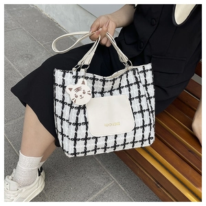 Borsa tote in tweed a scacchi con tasca in pelle e ciondolo in ambiente esterno