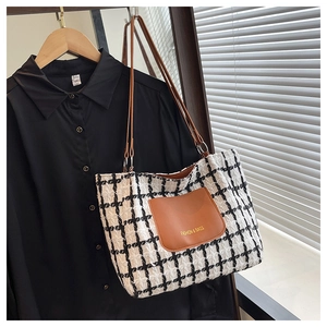 Dettaglio della borsa tote in tweed con tasca in pelle marrone e tracolle multifunzione