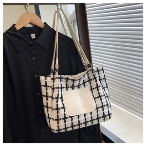 Dettaglio borsa tote in tweed con tasca in pelle beige e scritte dorate Fashion