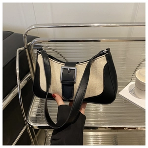 Detail of minimalist black and white woven canvas handbag with silver metal buckle