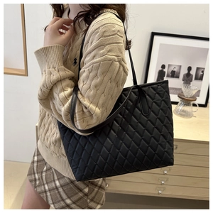 Gros plan détaillé d'un grand sac cabas noir matelassé avec surpiqûres à motif de losanges