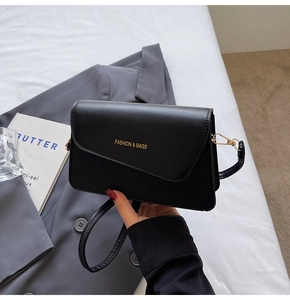 Close-up of black leather crossbody bag featuring gold Fashion & Bags lettering detail