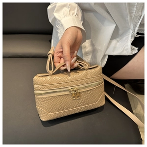 Detailed view of beige square handbag with crocodile texture and gold dual zippers