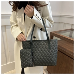 Détail du sac cabas matelassé gris foncé avec surpiqûres blanches et pochette assortie
