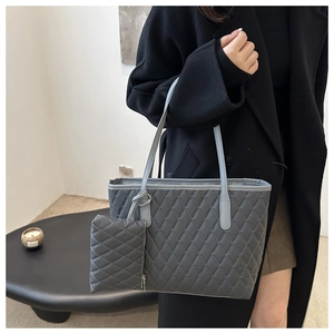 Détail du sac cabas matelassé gris montrant la texture en losanges et le petit porte-monnaie
