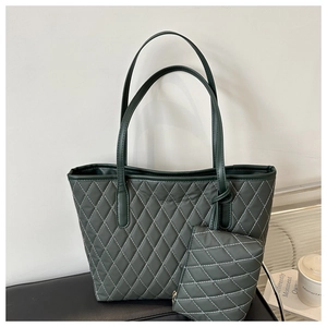Détail d'un sac cabas matelassé vert foncé avec pochette et surpiqûres blanches