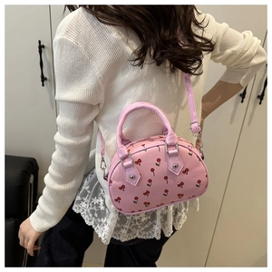 Adjustable shoulder strap of pink cherry print tote bag shown on a female model