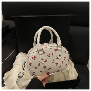 Detail of white cherry print handbag on luxury gift box with adjustable shoulder strap