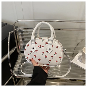 Detail of white mini crossbody bag featuring sweet cherry print and silver hardware