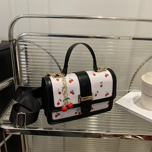 Retro white cherry print square crossbody handbag with black trim and a gold metal buckle