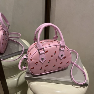 Pink cherry print crossbody bag with round top handles and detachable shoulder strap