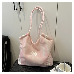 Detailed close-up of pink and white tie-dye tote bag with floral embroidery and rope handle