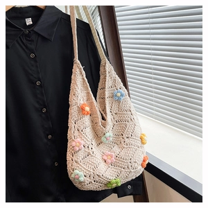 Vue détaillée d'un sac fourre-tout en crochet beige avec des fleurs tricotées en 3D