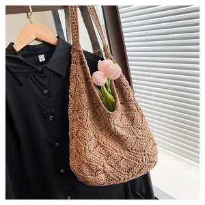 Gros plan d'un sac cabas en tricot marron avec texture géométrique 3D sur un cintre