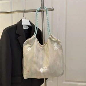 Floral tote bag with 3D daisy appliques and woven straps in minimalist chic style