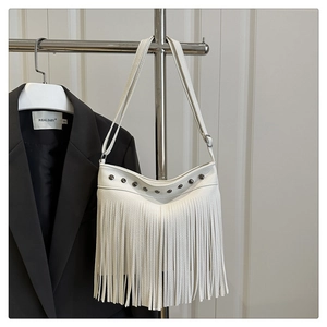 Detalle de bolso tote de cuero lichi blanco con flecos largos y remaches metálicos
