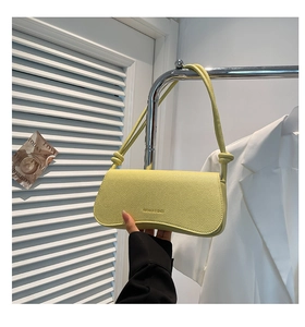 Close-up of yellow litchi texture shoulder bag with knot strap and lettering