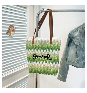 Detail of colorful woven straw tote with Summer embroidery and leather straps