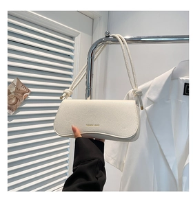 Detail of off-white lychee pattern leather shoulder bag with decorative knotted strap
