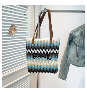 Detail of bohemian woven tote bag with Summer embroidery and brown leather handles