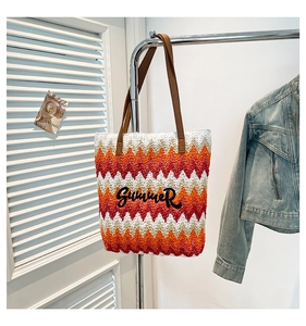 Detail of Summer embroidery and zigzag woven pattern on large straw tote bag with leather straps