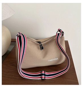 Détail du sac hobo en nylon montrant la texture kaki et la bandoulière rayée colorée