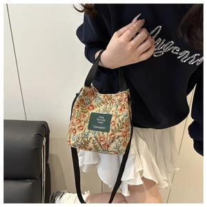 Floral canvas mini tote bag shown as a crossbody bag on a model in casual attire
