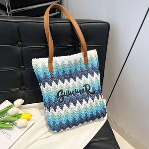 Large woven tote bag with blue zigzag pattern and Summer embroidery on a leather chair