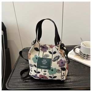 Detail of floral jacquard fabric and green leather label on the casual tote bag