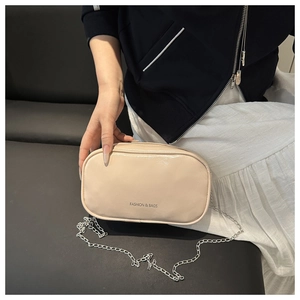 Fashionable cream PU leather crossbody bag with chain strap and printed text shown on a model