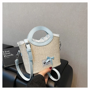 Close-up of woven straw handbag featuring white lace trim and light blue leather bow