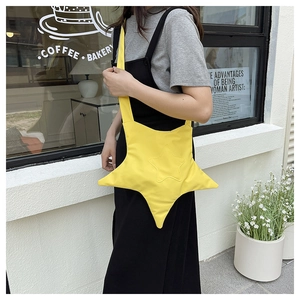 Detail of star-shaped crossbody bag in bright yellow canvas on a minimalist model