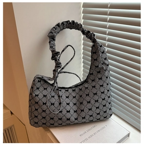 Close-up of ruched shoulder strap and black bow detailing on a gingham shoulder bag