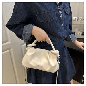 Détail d'un sac nuage en cuir plissé avec poignée nouée et bandoulière amovible élégante