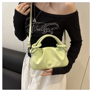 Détail du sac à main plissé vert clair avec poignée ronde et fine bandoulière réglable
