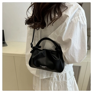 Détail du sac nuage en cuir plissé noir avec poignée cylindrique et lettrage logo