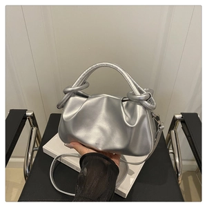 Detailed shot of silver pleated cloud bag with metallic finish and brand logo
