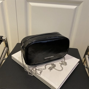 Sleek black glossy mini makeup bag with silver chain strap and top zipper closure