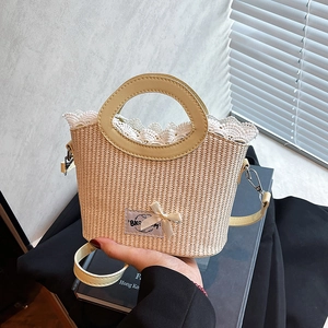 Handheld woven straw bucket bag with yellow handles, lace trim, and a purple bow detail