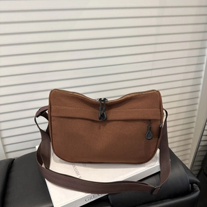 Large dark brown canvas shoulder bag with adjustable strap and front zipper pocket