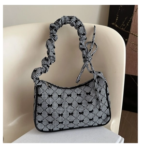 Detail of checkered tote bag with black bows and scrunchie pleated handle on display